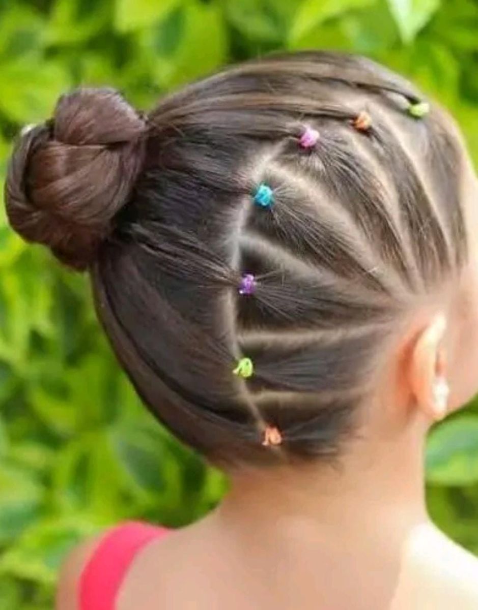 Moño alto con trenza lateral y ligas de colores