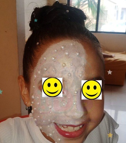 Niña con maquillaje artístico y perlas en el rostro